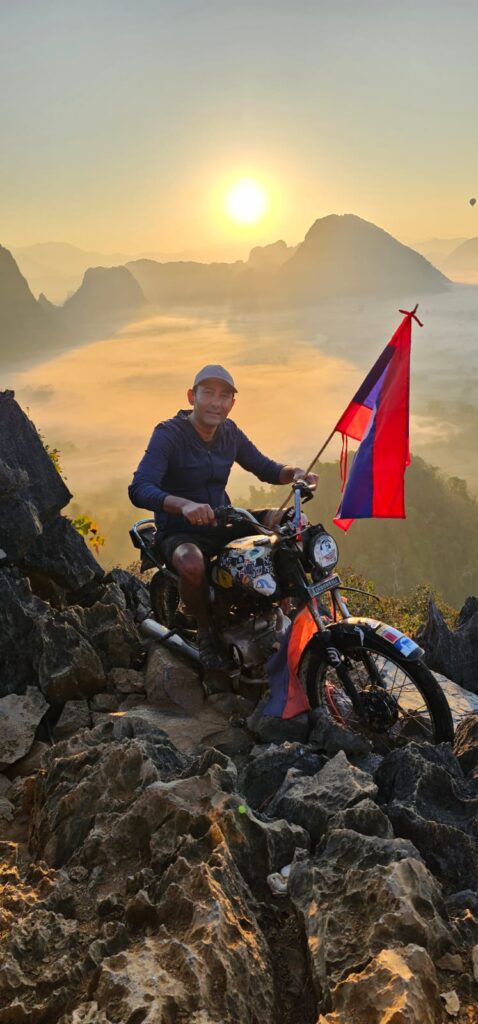 Breathtaking mountain landscape in Laos with a motorbike rider in the foreground.