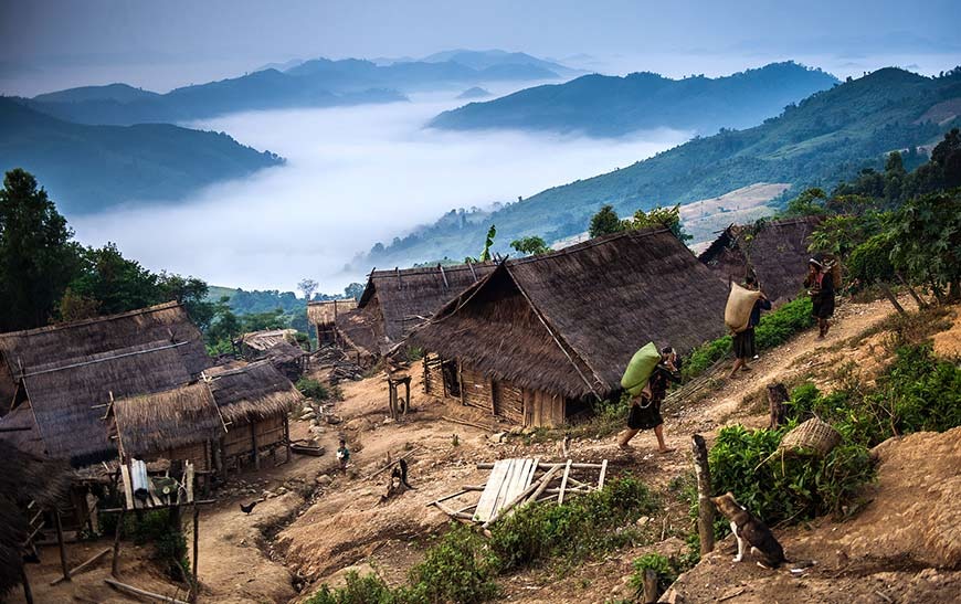 Scenic view of Phongsaly Province in Northern Laos, showcasing terraced rice fields, dense forests, and mist-shrouded mountains.