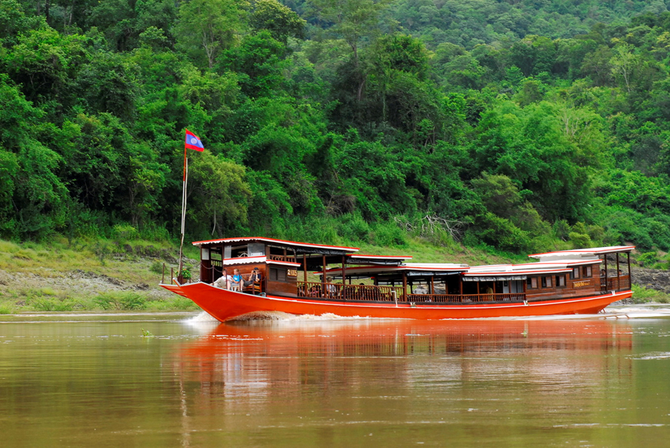 Scenic view of the Mekong River in Northern Laos, showcasing a river cruise, lush landscapes, and traditional villages.